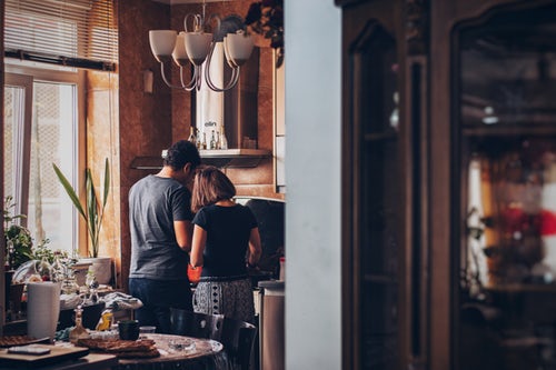 man and woman standing in kitchen